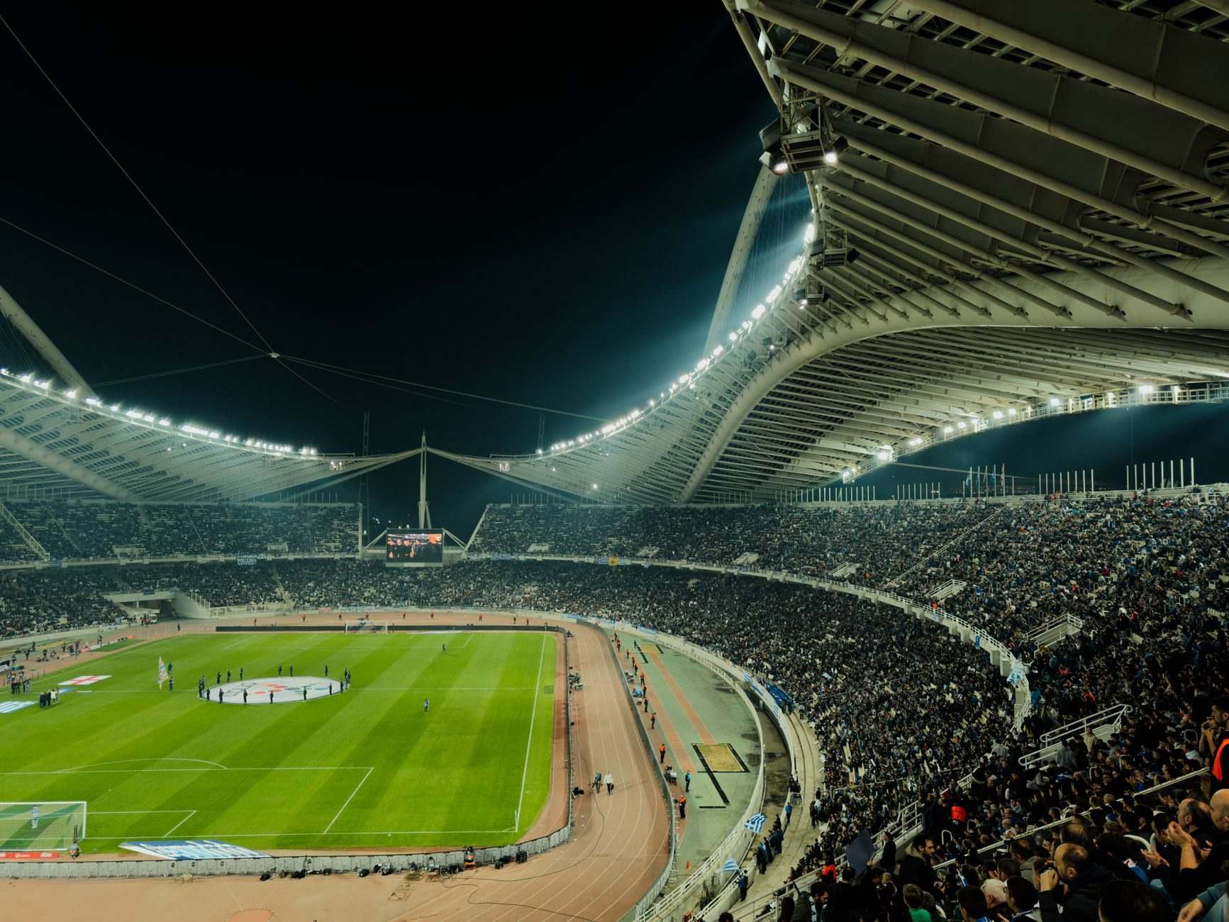 A packed stadium under floodlights on a match night